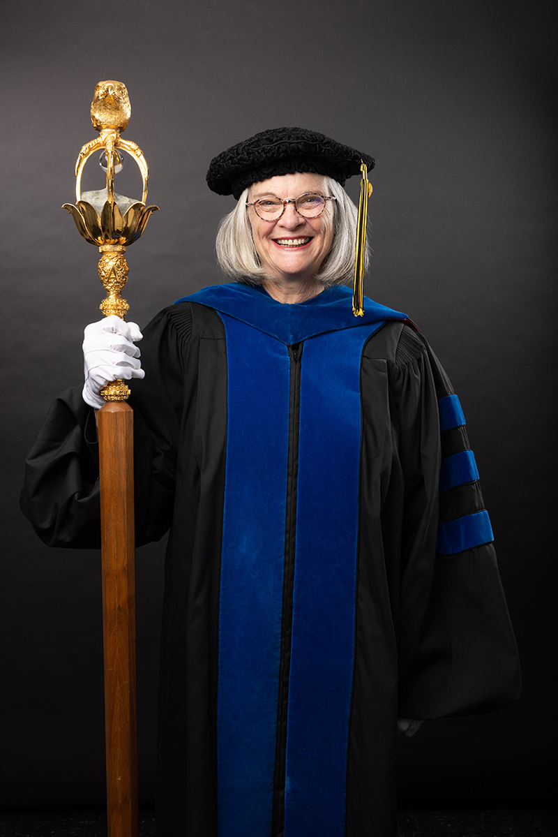 Dr. Janice Pope holding the university mace.